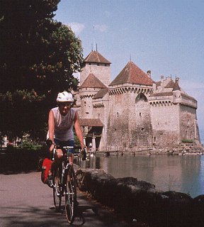 A cyclist pedals past Chillon Castle in Montreux.